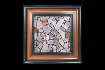 stone background of marble pieces of different sizes in a wooden frame on a dark background