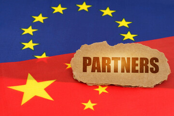 On the flags of China and the European Union lies a cardboard plate with the inscription - Partners
