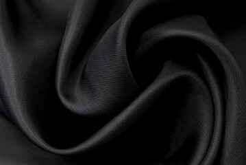 Part of the dark fabric texture of the fabric for the background and decoration of the work of art, a beautiful crumpled pattern of silk or linen. A crumpled piece of cloth