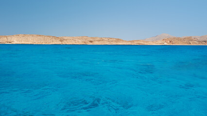 Blue sky and sea background. View from the ocean to the shore