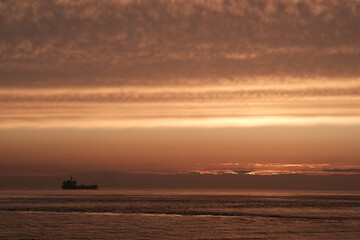 Naklejka na ściany i meble industry ship driving into dramatic ocean sunset