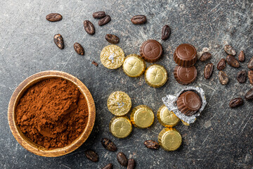 Wrapped chocolate pralines. Sweet chocolate bonbons and cocoa powder.