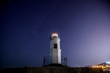 Lighthouse Tokarevsky in Vladivostok at night. Starry against the backdrop of a beautiful lighthouse.