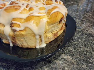 Close up of dripping white icing on homemade cinnamon rolls