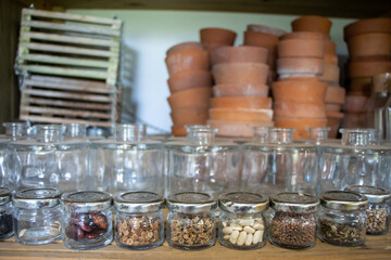 Jars of seeds on a shelf in a garden shelter.