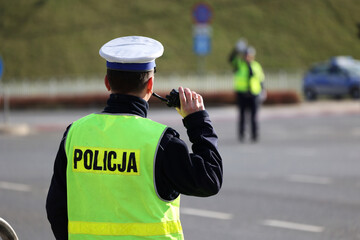  Policjant policji drogowej podczas kierowania ruchem z lizakiem do zatrzymywania pojazdów. © FotoDax