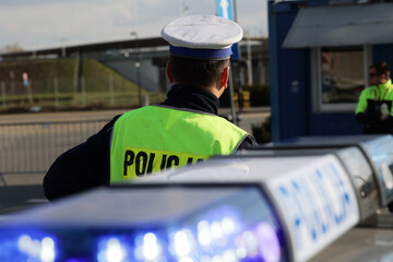  Policjant policji drogowej podczas kierowania ruchem z lizakiem do zatrzymywania pojazdów. © FotoDax