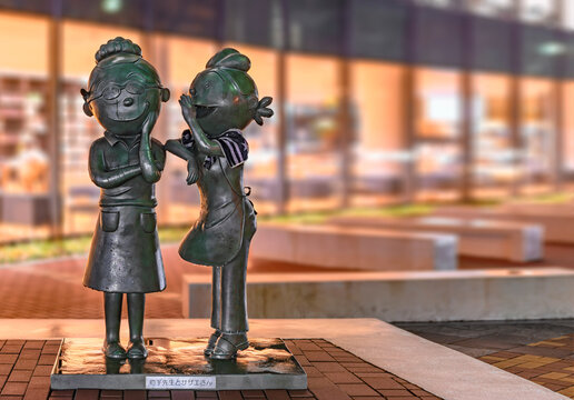 fukuoka, japan - april 20 2022: Bronze statues of character Sazae Fuguta on right from the manga and anime series Sazae-san and her creator the mangaka Machiko Hasegawa at Sazaesan Street in Kyushu.