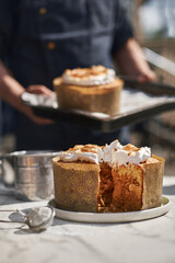 Traditional Russian and Ukrainian kulich kulich stuffed with condensed milk, freshly baked. Confectioner in the background