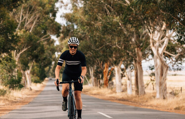Fototapeta na wymiar Professional woman cyclist riding her road bike on countryside