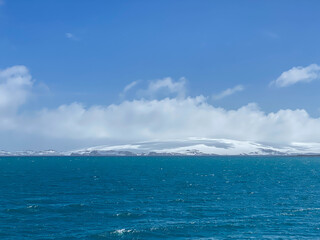 Naklejka na ściany i meble Blue sky and sea, shadow of cloud on snow island