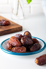Dried dates in the bowl on white background.