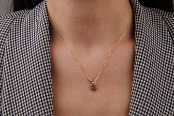 Close-up young woman wearing gold chain necklace. Modern fashion details. minimalist lifestyle