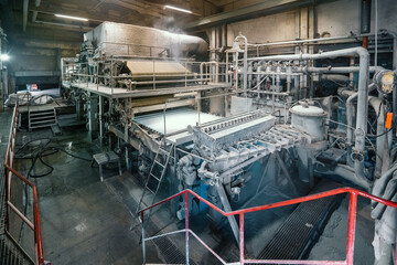 Paper production machine in wastepaper recycling factory. Paper and pulp mill. - obrazy, fototapety, plakaty