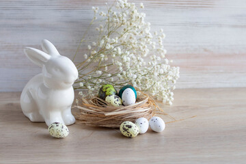 colored quail eggs and ceramic rabbit, easter theme