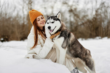young woman in the snow playing with a dog outdoors friendship fresh air