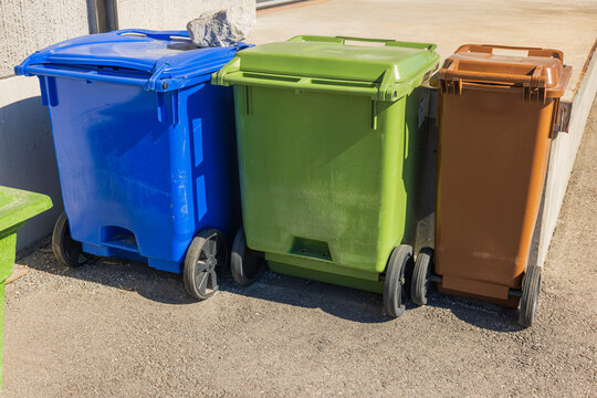 Close up of three trash cans for sorting storage of food waste, trash and paper for printing. Sweden.