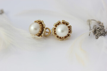 Close-up photo of white pearl earrings with diamonds in gold