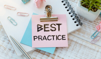 BEST PRACTICE text written on a pink paper on notebook