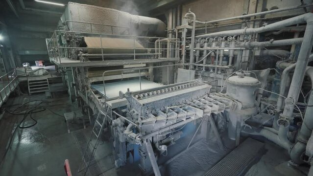 Paper production machine in wastepaper recycling factory. Paper and pulp mill.