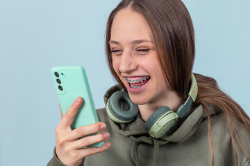 Young  girl in headphones with smartphone in hand has video call.
