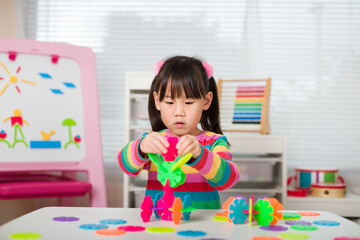young irl playing creative toy blocks at home