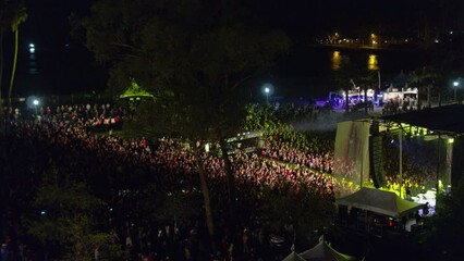 Aerial Forward Shot Of Musical Group Performing Live On Stage In Front Of People At Beach - Dana Point, California