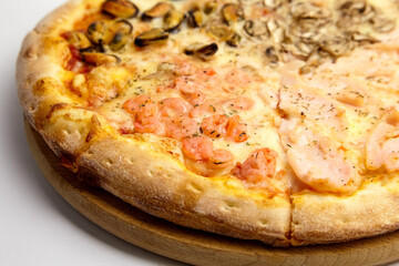 Seafood Pizza mix with mussels and shrimps on wooden cutting board on white