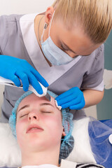 Naklejka premium Young woman getting ultrasonic peel skin with skin scrubber.