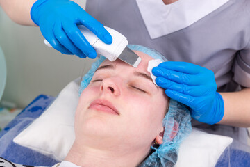 Young woman getting ultrasonic peel skin with skin scrubber.