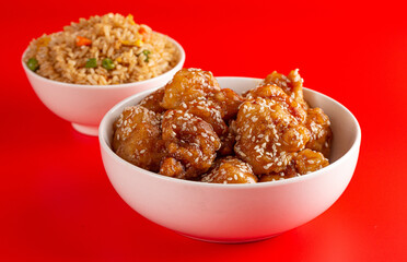 Bowl of Sesame Chicken on a Bright Red Background