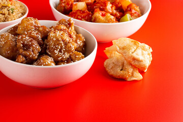 Bowl of Sesame Chicken on a Bright Red Background