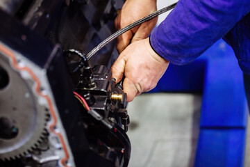 Obraz premium Industrial worker assembles machine, close up