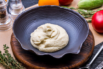 celery puree on a black bowl on wooden table