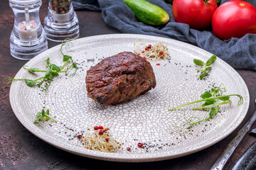 grilled steak filet Mignon on grey plate on dark stone table