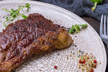 roast beef Steak Trytip on grey plate on dark stone table macro close up