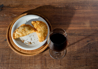 top view of glass with wine and wooden dish with two meat patties