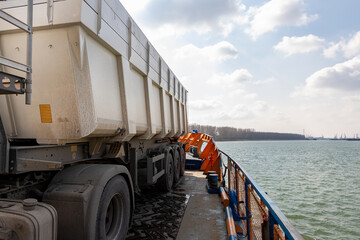 Close-up detail view of big industrial hopper truck body loaded on cargo ferry boat sailing on...