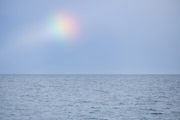 Blue sky, ocean and rainbow spot