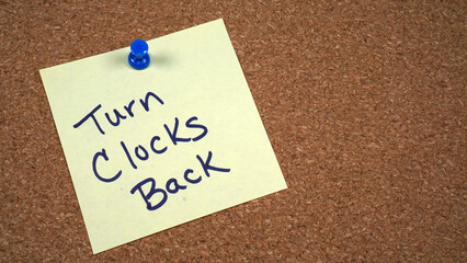 Note posted on a cork board with a reminder to turn clocks back at the end of Daylight Saving Time...