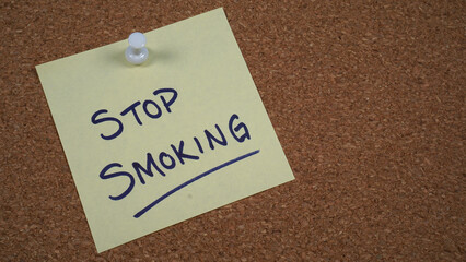 Note posted on a cork board with a reminder to stop smoking.