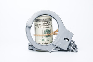 A picture of fake money and handcuff on white background. Money trap concept.