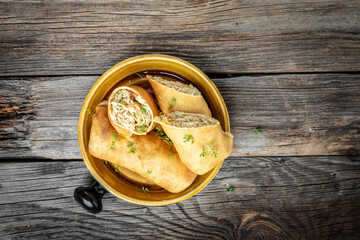 Savory crepe rolls, stuffed pancakes with ground meat filling. Traditional Maslenitsa festival meal on wooden background