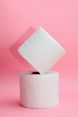 two white toilet papers on a pink background