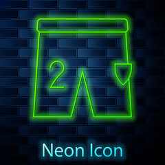 Glowing neon line Shorts for playing football icon isolated on brick wall background. Vector