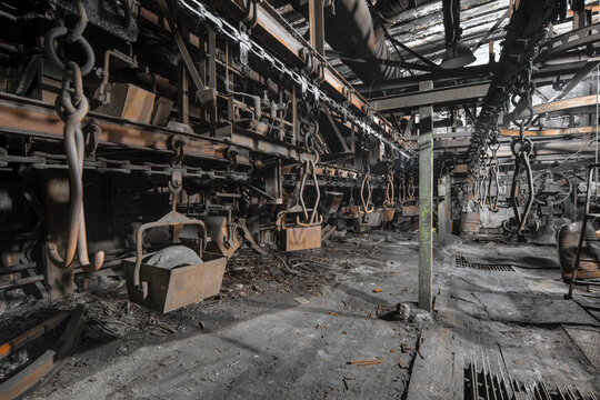 Old abandoned factory. Stopped overhead conveyor with hooks