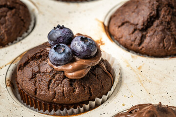 fresh baked muffins with chocolate cream and blueberries in ceramic pan