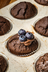 fresh baked muffins with chocolate cream and blueberries in ceramic pan