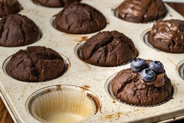 fresh baked muffins with chocolate cream and blueberries in ceramic pan
