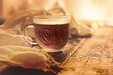 Cup of tea on wooden table with warm scarf, autumn minimal still life, atmosphere mood. Sepia toned